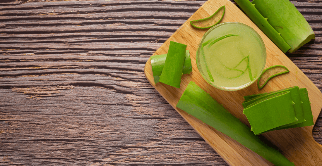 glass of aloe vera juice put on brown cutting board, what aloe vera juice does for the body, real aloe vera juice